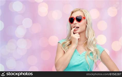emotions, expressions, summer and people concept - smiling young woman or teenage girl in sunglasses over pink holidays lights background
