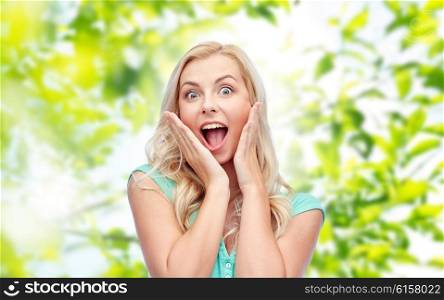 emotions, expressions, summer and people concept - surprised smiling young woman or teenage girl over green natural background