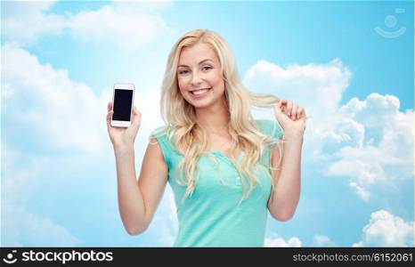 emotions, expressions, technology and people concept - smiling young woman or teenage girl showing blank smartphone screen over blue sky and clouds background