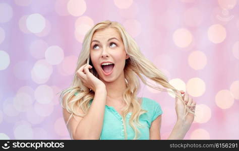 emotions, expressions, technology and people concept - smiling young woman or teenage girl calling on smartphone over pink holidays lights background