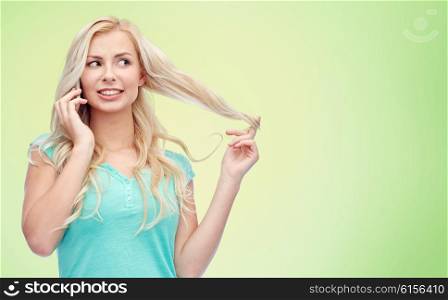 emotions, expressions, technology and people concept - smiling young woman or teenage girl calling on smartphone over green natural background