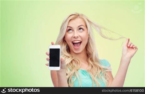 emotions, expressions, technology and people concept - smiling young woman or teenage girl showing blank smartphone screen over green natural background