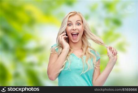 emotions, expressions, technology and people concept - smiling young woman or teenage girl calling on smartphone over green natural background