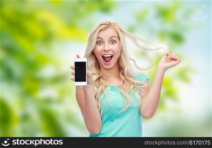 emotions, expressions, technology and people concept - smiling young woman or teenage girl showing blank smartphone screen over green natural background