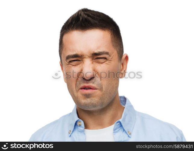 emotions, facial expression and people concept - man wrying of unpleasant smell