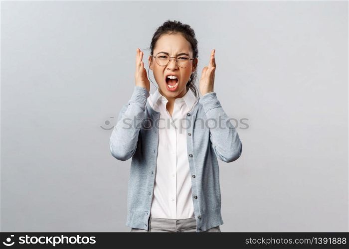 Emotions, people and lifestyle concept. Aggressive young annoyed asian woman have emotional working burnout, screaming with hate and rage, staring furious grimacing, shaking hands in anger.. Emotions, people and lifestyle concept. Aggressive young annoyed asian woman have emotional working burnout, screaming with hate and rage, staring furious grimacing, shaking hands in anger