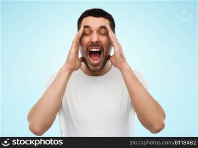 emotions, stress, madness and people concept - crazy shouting man in t-shirt over blue background