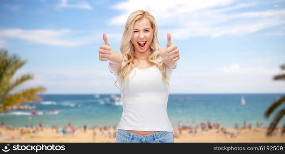 emotions, summer holidays, travel, advertisement and people concept - happy smiling young woman in white t-shirt showing thumbs up over exotic tropical beach with palm trees and sea background