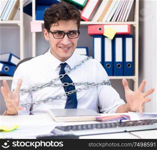 Employee attached and chained to his desk with chain. The employee attached and chained to his desk with chain
