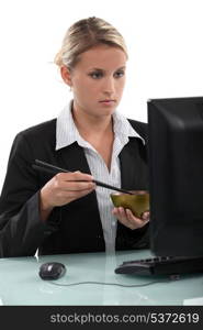 Employee eating at her computer