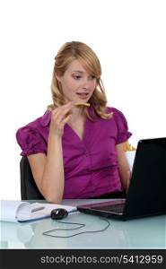 Employee eating French fries in front of her computer