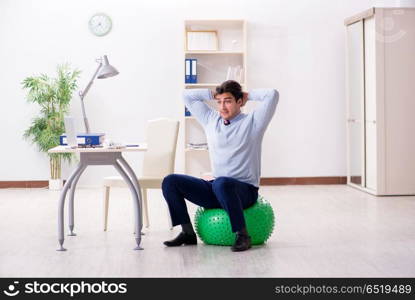 Employee exercising with swiss ball during lunch break