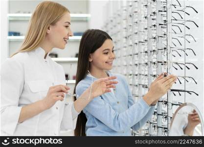 employee helping girl try glasses 8. employee helping girl try glasses 7