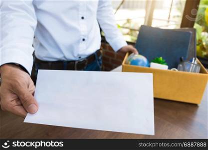 Employee holding resignation letter and Packing a Box To Leave The Office