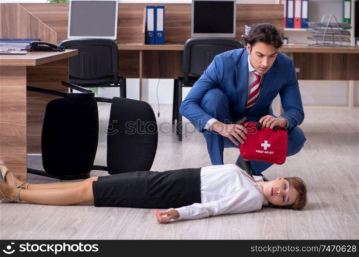 Employee receiving first aid in office. Young employee suffering in the office 