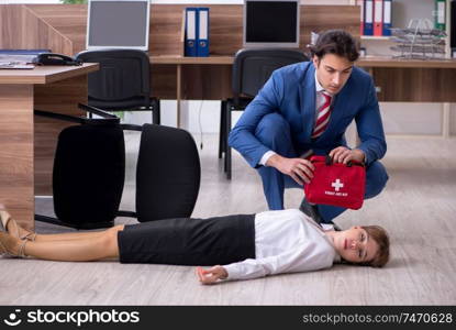 Employee receiving first aid in office. Young employee suffering in the office 