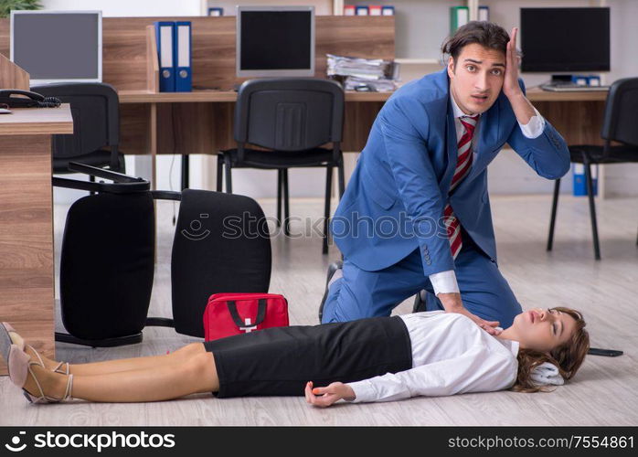 Employee receiving first aid in office. Young employee suffering in the office