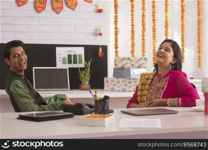 Employees laughing in office during Diwali celebration.  