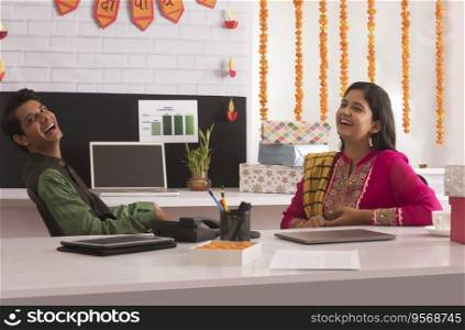 Employees laughing in office during Diwali celebration.  