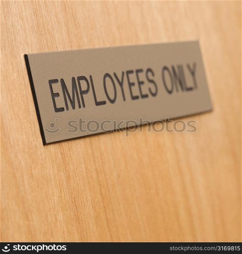 Employees only sign on wooden door.