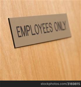 Employees only sign on wooden door.