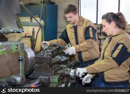 employees using industrial machinery at factory