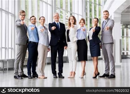 employment, work and corporate concept - happy business team pointing to camera at office building. business people pointing to camera at office