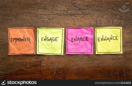 empower, engage, enable, and enhance inspirational concept - handwriting on isolated sticky notes against rustic wood