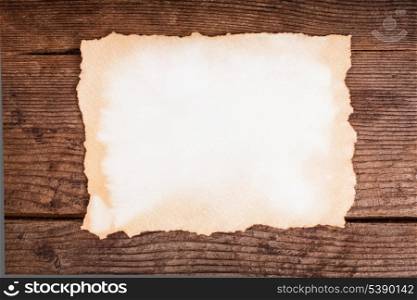 Empty aged paper on the wooden background