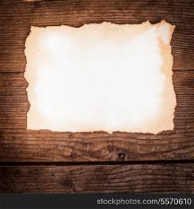 Empty aged paper on the wooden background