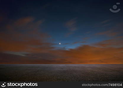 Empty asphalt floor with dramatic night sky .