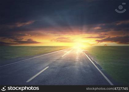 Empty asphalt road and sun rising at skyline. Sunrise above road