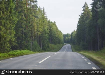 Empty asphalted forest road turn, Dalsland, Sweden in the summer.