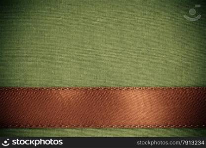 Empty banner on vintage background. Brown ribbon on green fabric cloth texture with copy space.