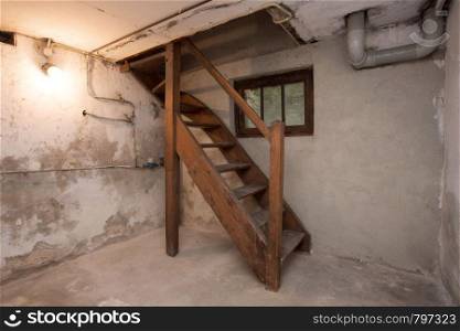 empty basement in abandoned old industrial building with little light and a wooden stairs darkness. empty basement in abandoned old industrial building with little light and a wooden stairs