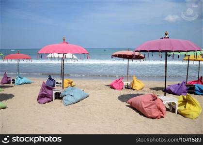 Empty beach background with bright tent, chairs, surf waves and sunny sky