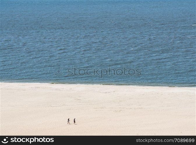 Empty beach scene on the coast at Cape May Point in New Jersey. Single couple on wide beach at Cape May Point in New Jersey