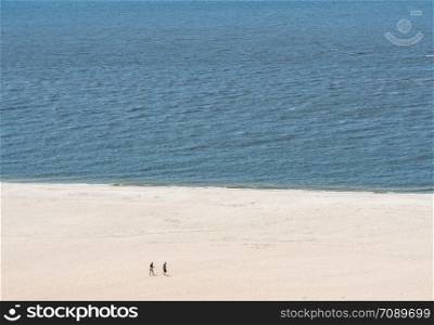 Empty beach scene on the coast at Cape May Point in New Jersey. Single couple on wide beach at Cape May Point in New Jersey