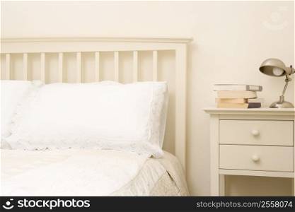 Empty bedroom with books on nightstand