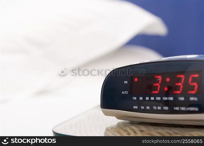 Empty bedroom with focus on alarm clock