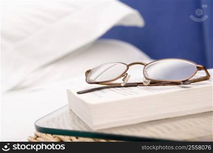 Empty bedroom with focus on eyeglasses and book