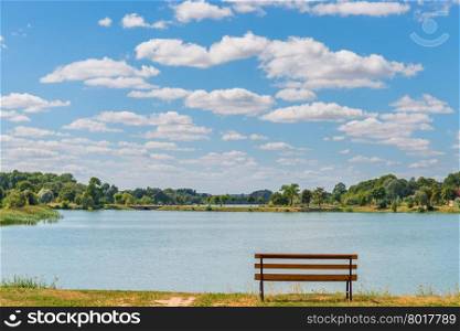 empty bench by the lake on a sunny day