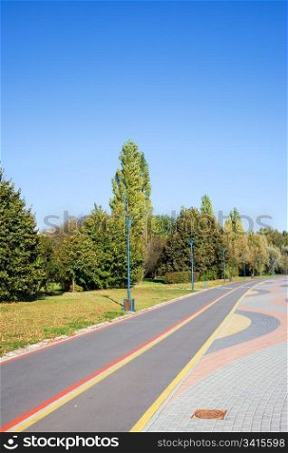 Empty bicycle path in a park on a sunny, tranquil day, composition with copyspace