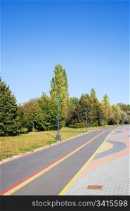 Empty bicycle path in a park on a sunny, tranquil day, composition with copyspace