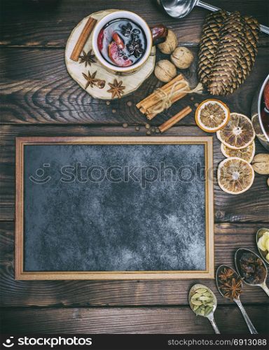 empty black frame and ingredients for mulled wine preparation, top view, vintage toning
