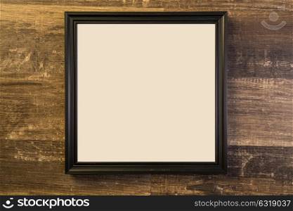 empty black frame on wood wall