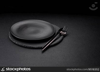 Empty black plate over dark stone background with copy space. Top view