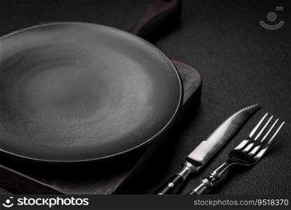 Empty black plate over dark stone background with copy space. Top view