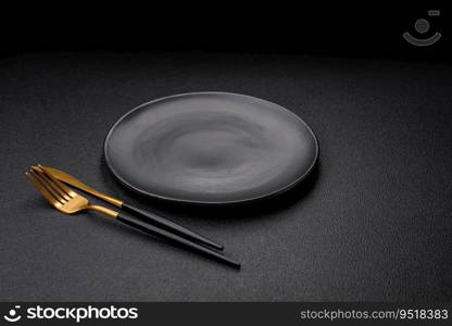 Empty black plate over dark stone background with copy space. Top view