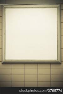 Empty blank square white advertising billboard on tiled wall. Information. Promotion of your product. Real. Sepia tone.